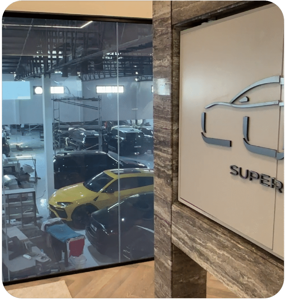 A modern open-plan office in Dubai with a smart glass conference room partition, shown in its clear 'ON' state.